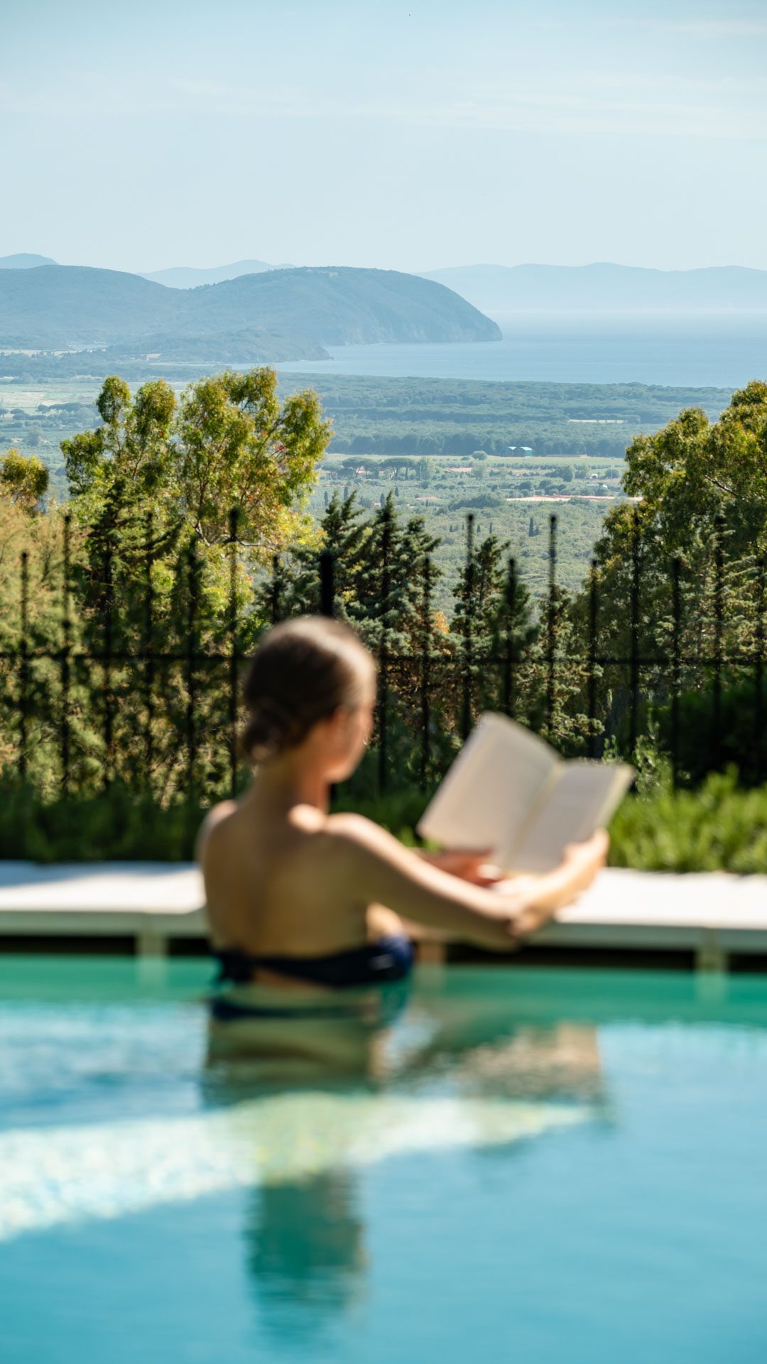 Lettura nella piscina a sfioro con vista sul mare, Poggio ai Santi